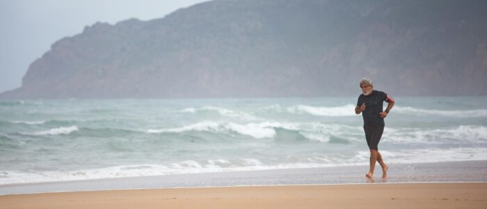 Photo by Kampus Production Elderly man maintaining fitness by running along a scenic beach in Portugal.