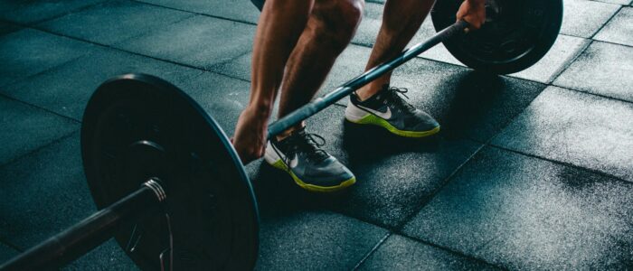 Photo by Victor Freitas Man performing a deadlift exercise in a gym, demonstrating strength and fitness.